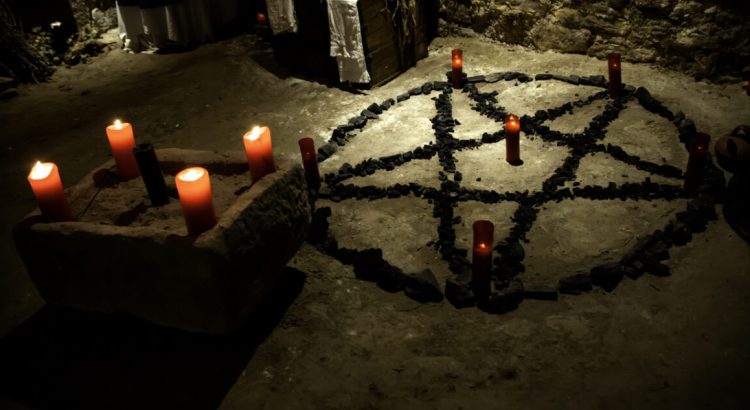 satanic ritual altar, pentagram with candles beside it.